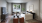 Living room with windows, couch, flat screen tv and console with windows looking outside.\