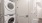 A room with a  white washer and dryer stacked on top
