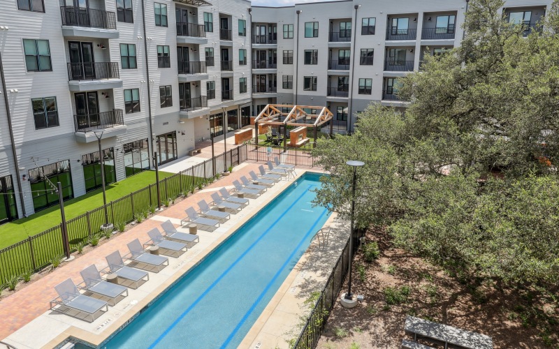 A long swimming pool with tanning deck and chairs
