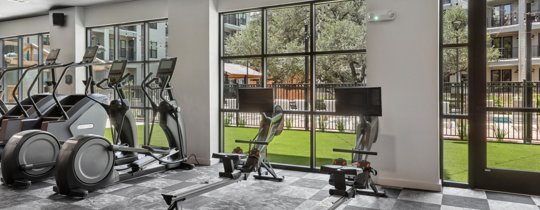 a fitness center with equipment and green space