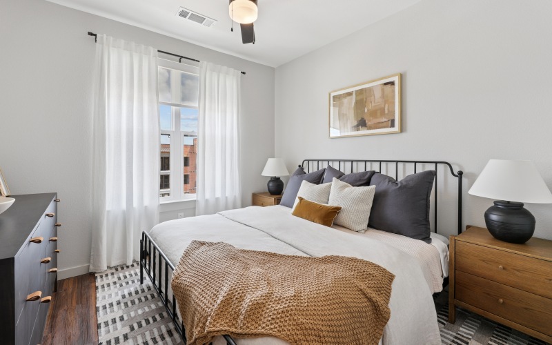 a room with a bed , night stands, and dresser