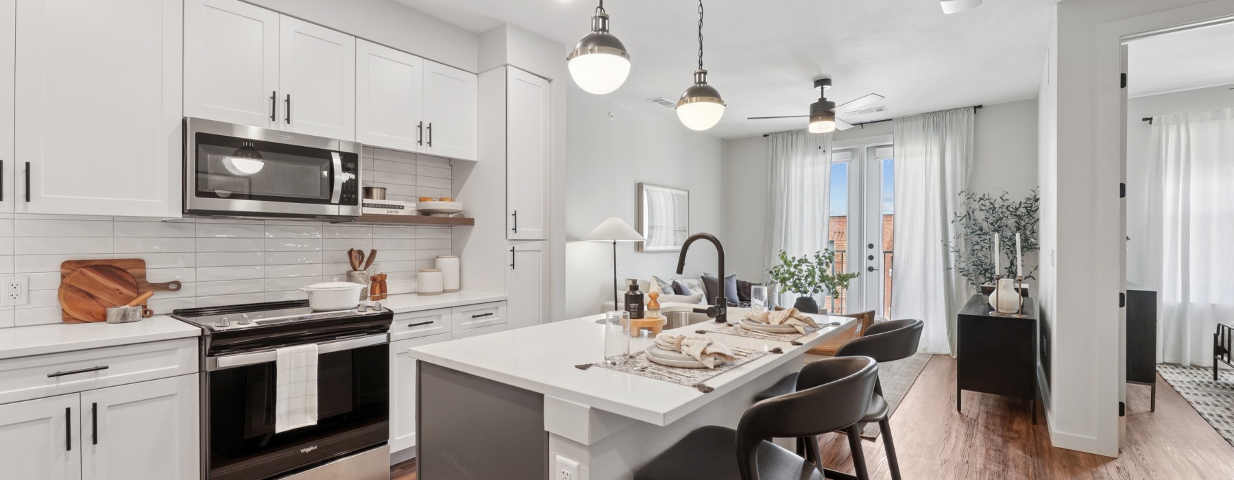 An open concept kitch and living room with stainless steel appliances