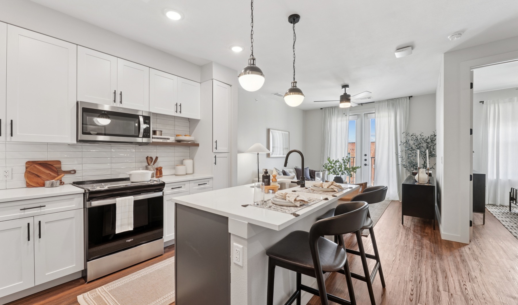 a kitchen with white cabinets, stainless steel appliances and open concept